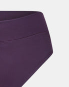 Nahaufnahme der Alice Bikini Hose von Main Design, einem hoch taillierten, dunkelvioletten Bikiniunterteil aus recycelten Materialien. Der glatte, dehnbare Stoff und die minimalen Nähte sorgen für einen eleganten Look vor einem schlichten weißen Hintergrund.