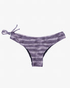 Ein Paar lila Batik-Blush-Surf-Bikinihosen von Main Design mit seitlichem Bindedetail auf der linken Seite. Der Stoff weist horizontale Streifen in verschiedenen Lilatönen auf, die ihm ein dezent gestreiftes Aussehen verleihen. Diese Bikinihose ist aus umweltfreundlichem Stoff gefertigt und hat eine niedrige Leibhöhe.