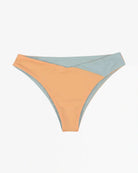 Die Flair Bikinihose von Main Design aus der Cali Coast Collection verfügt über einen Colorblock-Stil in pastellfarbenem Pfirsich und Hellblau, wodurch eine atemberaubende Überlappung auf einem glatten, nahtlosen Stoff vor einem schlichten weißen Hintergrund entsteht.