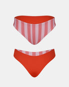 Die Luxe Bikini Hose von Main Design ist hoch tailliert und brasilianisch geschnitten. Sie ist auf der einen Seite rosa und weiß gestreift und auf der anderen Seite einfarbig leuchtend rot vor weißem Hintergrund.