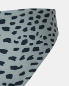 Nahaufnahme der Luxe Bikini Hose von Main Design, die aus recycelten Materialien hergestellt wurde. Ein unregelmäßiger schwarzer Fleckentierdruck auf hellgrauem Grund - ein stilvolles Bademoden-Essential.