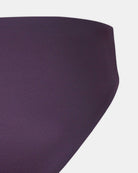 Nahaufnahme der Seite der Luxe Bikini Hose von Main Design in tiefem Violett, mit einem hoch taillierten brasilianischen Schnitt auf weißem Hintergrund. Der glatte, nahtlose Stoff ist aus recycelten Materialien hergestellt.