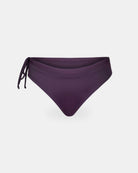 Die Main Design Tide Surf Bikini Hose in dunklem Lila verfügt über ein verstellbares Drawstring-Band und ein seitliches Bindedetail auf der linken Seite, abgebildet auf einem schlichten weißen Hintergrund.