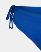 Nahaufnahme der Main Design Tide Surf Bikini Hose in blau, mit einem verstellbaren Drawstring-Bund mit zwei dünnen Seitenbändern. Der glatte, dehnbare Stoff wird vor einem weißen Hintergrund gezeigt.