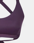 Nahaufnahme des Charm Surf Bikini Oberteils von Main Design in Lila, mit gekreuzten Trägern und glattem Stoff, mit UPF 50+ Schutz, gezeigt vor einem einfarbig weißen Hintergrund.