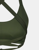 Nahaufnahme des Charm Surf Bikini-Oberteils von Main Design in Olivgrün mit überkreuzten Trägern, sichtbaren Nähten und UPF 50+ Sonnenschutz, inspiriert von Surf-Styles, vor weißem Hintergrund.