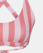 Nahaufnahme des Charm Surf Bikini-Oberteils von Main Design mit breiten rosa und hellrosa Streifen, überkreuzten Trägern auf dem Rücken, UPF 50+ Sonnenschutz und einem Bindeband am Po.