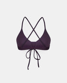Das Drift Surf Bikini Oberteil von Main Design ist ein dunkelviolettes Oberteil im Bralette-Stil aus nachhaltigen Materialien, mit dünnen, überkreuzten Trägern und einem Bindeverschluss. Sein schlichter, moderner Look hebt sich von dem schlichten weißen Hintergrund ab.