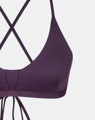 Nahaufnahme des Drift Surf Bikini Oberteils von Main Design in dunklem Lila, mit dünnen, überkreuzten Rückenträgern und glatten, nachhaltigen Materialien für einen minimalen, modernen und umweltfreundlichen Stil.