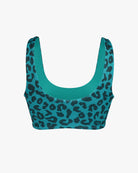 Das Hale Bikini-Oberteil von Main Design besticht durch einen blaugrünen und schwarzen Leopardenprint, ein wendbares Design, einen schmeichelhaften Rundhalsausschnitt und breite Träger für volle Bedeckung. Das auffällige Muster sticht auf schlichtem weißem Hintergrund hervor und bietet dank LSF 50+ zusätzlichen Sonnenschutz.