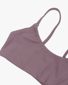Ein malvenfarbenes „Sassy“-Bikinioberteil von Main Design mit minimalistischem, nahtlosem Design mit dünnen Trägern und aus recycelten Materialien wird flach auf einem weißen Hintergrund präsentiert.