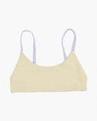 Ein hellgelbes Wende-Bikinioberteil mit dünnen Trägern von Main Design, gefertigt aus nachhaltigen Materialien, ruht auf einem schlichten weißen Hintergrund.