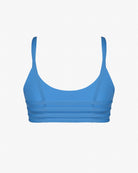 Das Sassy Bikini Oberteil reversibel von Main Design ist ein blauer Sport-BH aus chlorresistenter Stoff mit dünnen Schulterträgern und horizontalen Mesh-Einsätzen an den Seiten und am Rücken, vor einem schlichten weißen Hintergrund.