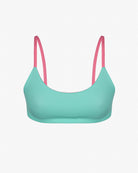 Das Sassy Bikini Oberteil reversibel von Main Design ist ein wendbares Bikinioberteil mit türkisfarbenem BH und rosa Trägern auf weißem Hintergrund, hergestellt aus chlorbeständigem Material für Langlebigkeit.