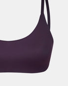 Nahaufnahme des Main Design Sassy Bikini-Tops in dunklem Lila mit dünnen Trägern, hergestellt aus recycelten Materialien, vor weißem Hintergrund.