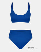 Das königsblaue Sassy Bikini-Top von Main Design hat einen Rundhalsausschnitt und ein hoch tailliertes Unterteil aus recycelten Materialien. Auf einfarbig weißem Hintergrund mit Text: "Besser zusammen Sassy Top | Alice Bottom".