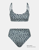 Zweiteiliger Badeanzug von Main Design mit Sassy Bikini-Top mit Rundhalsausschnitt und hochtailliertem Unterteil aus recycelten Materialien. Hellgraue Basis mit unregelmäßigen schwarzen Flecken. Text "Better together Sassy Top | Alice Bottom" in der Ecke.