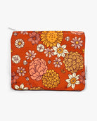 Die Bikinitasche von Several Needs by Main Design ist eine handgefertigte, rechteckige Tasche mit Reißverschluss und leuchtenden Blumenmustern in Gelb, Rosa und Creme auf orangefarbenem Hintergrund. Sie eignet sich ideal als wasserabweisende Bikinitasche und verfügt über ein kleines Seitenetikett.