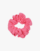 Das Haargummi einfarbig von Main Design ist ein leuchtend rosa, rundes Haargummi mit einer gerüschten Textur, das aus Stoffresten besteht und auf einem schlichten weißen Hintergrund abgebildet ist.
