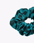 Nahaufnahme des von Main Design gemusterten Haargummis in blaugrünem und schwarzem Muster auf weißem Hintergrund, nachhaltig gefertigt aus Stoffresten – ein stilvoller Scrunchie für umweltbewusste Trendsetter.