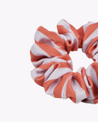 Eine Nahaufnahme des „Haargummi gemustert“ von Main Design mit orangefarbenen und weißen diagonalen Streifen aus Stoffresten, die für einen nachhaltigen Touch vor einem schlichten weißen Hintergrund gezeigt werden.