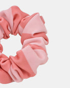 Eine Nahaufnahme des Haargummi gemustert von Main Design mit rosa und hellrosa Streifen vor einem einfarbig weißen Hintergrund.