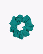Das Haargummi Mini von Main Design ist ein türkisfarbenes Scrunchie aus recyceltem Stoff, das in kreisförmiger Form vor einem schlichten weißen Hintergrund dargestellt ist.