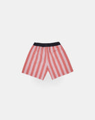 Ein Paar Lean Boardshorts für Jungen von Main Design mit vertikalen rosa und roten Streifen, schwarzem Gummibund und Gesäßtasche auf weißem Grund. Hergestellt aus schnell trocknendem Stoff für Komfort.