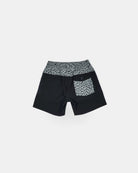 Die Nolan Boardshorts für Jungen von Main Design hat einen schwarzen Body mit grauem Bund, Taschenklappe und Seitenpaneel, alles mit einem unregelmäßigen schwarzen Punktmuster. Diese 4-Wege-Stretch-Shorts haben eine rechte Gesäßtasche mit Knopfverschluss. Abgebildet auf Weiß.