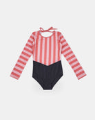Der Kaia Mädchen Badeanzug von Main Design hat rosa und rote vertikale Streifen auf dem Oberteil und den Ärmeln, eine einfarbige schwarze Unterseite, einen Rundhalsausschnitt mit Bindeband im Rücken und UPF 50+ Sonnenschutz. Abgebildet flach auf weißem Hintergrund.