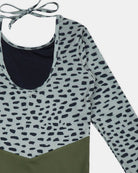 Eine Nahaufnahme des Badeanzugs Kaia Mädchen von Main Design mit Rundhalsausschnitt, Nackenband, Oberteil mit schwarzem und grauem Leopardenmuster, einfarbigem olivgrünem Unterteil und UPF 50+ Sonnenschutz für sonnige Tage.