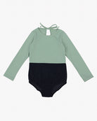 Der Laila Mädchen Badeanzug von Main Design ist ein langärmliger, zweifarbiger Badeanzug mit mintgrünem Oberteil und schwarzem Unterteil. Er hat einen schlüssellochförmigen Ausschnitt auf der Rückseite mit einem Bindeverschluss am Hals. Dieses elegante Design aus umweltfreundlichem Stoff mit LSF 50+ Sonnenschutz ist perfekt für Kinder.