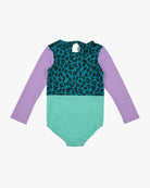 Der Laila Mädchen Badeanzug von Main Design ist ein langärmliger Badeanzug für Kinder mit lavendelfarbenen Ärmeln, blaugrünem und schwarzem Leopardenmuster oben, mintgrünem unteren Teil, LSF 50+ Sonnenschutz und einem Schlüssellochausschnitt mit Schleife hinten.