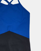 Nahaufnahme des Lena Mädchen Badeanzugs von Main Design, ein nachhaltiger Badeanzug für Mädchen mit einem ärmellosen, sportlichen Oberteil, überkreuzten Trägern, einem blauen Oberteil und einem schwarzen Unterteil, das durch eine diagonale Naht getrennt ist. Hergestellt aus recycelten Materialien; abgebildet auf weißem Hintergrund.