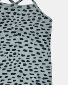 Nahaufnahme der Lena Mädchen Badeanzug von Main Design mit dünnen Trägern, mit einem schwarzen unregelmäßigen Punktmuster auf hellgrau, erinnert an Tierdruck. Hergestellt aus recycelten Materialien für eine umweltfreundliche Option.