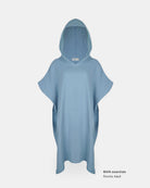 Hellblauer Shoreline Breeze Poncho von Main Design für Erwachsene, abgebildet auf einem schlichten weißen Hintergrund. Mit kurzen, weiten Ärmeln und einer lockeren Passform. In der unteren rechten Ecke steht "MAIN essentials Poncho Baumwolle Adult".