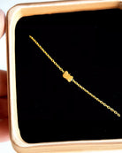 Das Armband von Adorabili by Adorabili ist ein zartes Armband aus 24-karätigem Gold mit einem kleinen Schmetterlingsanhänger, handgefertigt in Frankreich und präsentiert auf schwarzem Samt in einer Schmuckschatulle.