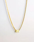 Die Halskette von Adorabili ist eine zarte 24 Karat vergoldete Goldkette mit einem schlichten goldenen Regenbogen-Anhänger, der auf einem schlichten weißen Hintergrund abgebildet ist.