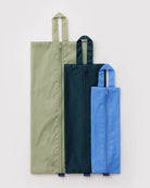 Drei BAGGU 3D Zip Set-Taschen von BAGGU - rechteckig, mit Henkeln in Grün, Marineblau und Hellblau - sind nebeneinander auf weißem Hintergrund abgebildet; praktische Reiseausrüstung für umweltbewusste Taschenliebhaber.