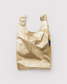 BAGGU Baby Tragetasche in Gold Metallic: Kleine goldfarbene Tragetasche mit Metallic-Oberfläche.