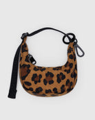 Der „BAGGU Crescent Bag Charm“ von BAGGU ist ein kleines, halbmondförmiges Accessoire mit einem braun-schwarzen Leopardenmuster, einem schwarzen Reißverschluss, einem abnehmbaren schwarzen Riemen und zwei schwarzen Clips. Es wird vor einem einfarbigen hellgrauen Hintergrund präsentiert.