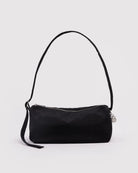 Eine schwarze „BAGGU Nylon Loaf Bag“ von BAGGU mit kurzem Trageriemen, Reißverschluss, seitlicher Quaste und einem kleinen runden silbernen Anhänger ist vor einem schlichten weißen Hintergrund abgebildet.