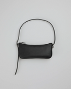 Eine kompakte, rechteckige schwarze BAGGU Recycled Leather Pochette mit einem Reißverschluss und einem einzelnen langen Riemen, hergestellt aus recyceltem Leder von BAGGU, dargestellt auf einem schlichten hellgrauen Hintergrund.