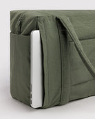 BAGGU Small Cloud Carry-On Tasche in Caper: Seitliches Reissverschlussfach der olivgrünen Tasche mit Laptop.