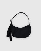 Die BAGGU Small Nylon Crescent Bag in klassischem Schwarz aus recyceltem Nylon verfügt über einen kurzen Trageriemen und ein zusätzliches Stoffband an der Seite - ideal für umweltbewusste Einkäufer. Abgebildet vor einem hellgrauen Hintergrund.