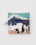 Die BAGGU Standard Tragetasche von BAGGU ist eine nachhaltige, faltbare Einkaufstasche aus recyceltem Ripstop-Nylon mit farbenfrohem Pinguin-Muster, sandigem Boden, blauem Himmel und einer kleinen Schlaufe an der Seite.