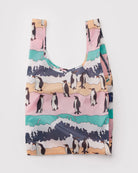 Die BAGGU Standard Tragetasche der Marke BAGGU besteht aus recyceltem Ripstop-Nylon und zeigt ein buntes Pinguin- und Wellenmuster in Pink, Teal, Gelb und Navy auf Weiß. Sorgfältig gefaltet, wird sie vor weißem Hintergrund präsentiert.