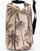 Die Dry Bag von Meraki Supply Co. by Main Design in Beige mit tropischem Palmen-Print und dem „MERAKI SUPPLY CO.“-Logo ist perfekt zum Transportieren Ihrer Reiseutensilien. Die Tasche verfügt über einen verstellbaren schwarzen Schultergurt und einen Rollverschluss für zusätzliche Sicherheit.