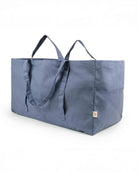 Die große Stofftasche von OMOM der Marke Main Design aus robustem, blauem Baumwoll-Canvas mit zwei Henkeln und Seitentaschen ist vor weißem Hintergrund zu sehen.