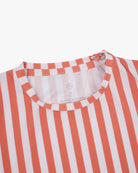 Nahaufnahme des Aina Kinder UV-Shirts von Main Design mit rot-weißem Streifenmuster und rundem Ausschnitt. Der leichte, gerippte Stoff trocknet schnell und bietet LSF 50+. Ein kleines Logo befindet sich im Nackenbereich.